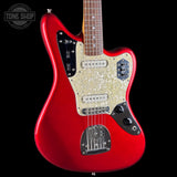 A red electric guitar with a glittering gold pickguard, shown from the side against a black background. The Tone Shop logo is visible in the top-left corner.