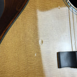 Close-up of a guitar with a visible scratch on the body