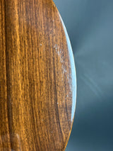 Close-up of a wooden surface with a blueish tint on a dark background