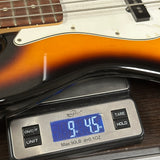 A close-up of a three-tone electric guitar body resting on a digital scale, showing the scale reading 9 lbs 45 oz. The scale is branded 'Ninja Dials'.