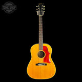 A Taylor acoustic guitar with a natural wood finish and a red pickguard, shown against a solid black background with a Tone Shop watermark in the top left corner.