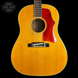 An acoustic guitar with a natural wood finish and a glossy red pickguard, shown against a solid black background with a Tone Shop watermark in the top-left corner.
