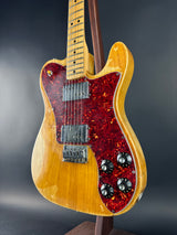 Electric guitar with a red flame maple top on a dark background
