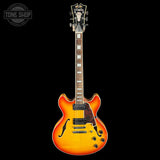 Electric guitar with a sunburst finish on a black background, featuring the Tone Shop logo.