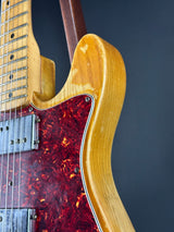 Close-up of a guitar's neck and body with a dark background