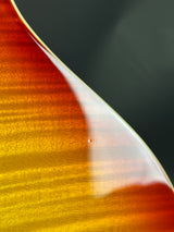 Close-up of a guitar's wooden neck with a gradient of colors.