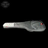 A gray padded guitar or bass gig bag with a white zippered pocket on the upper left, shown against a solid black background. A circular Tone Shop logo is visible in the top-left corner.