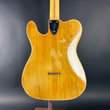 Back of a guitar with a Fender logo on a dark background