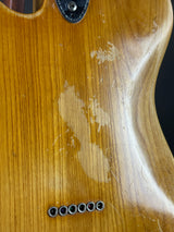 Close-up of a guitar's wooden body with visible wear and screws.