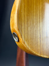 Close-up of a wooden object with a metal screw on a dark background