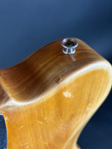 Close-up of a wooden guitar neck with a screw on a blue background