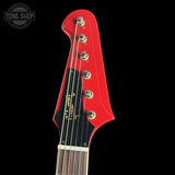 Close-up of a red electric guitar headstock with Fender logo on a black background.