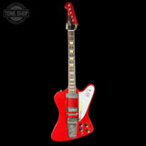 Red electric guitar with a white pickguard on a black background, featuring 'Tone Shop' branding.