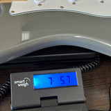 Used PRS SE Silver Sky Gray on scale displaying weight.