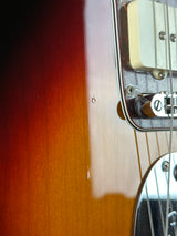 Close-up of a sunburst electric guitar body showing the glossy wood finish, pickups, and hardware.