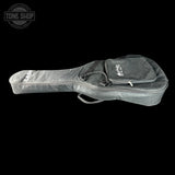 A black padded guitar or ukulele case with a zippered pocket and drawstring, shown against a solid black background. The Tone Shop logo is visible in the top-left corner.