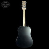 The back view of a matte black acoustic guitar against a solid black background, featuring a light natural wood neck and silver tuning keys. A 'TONE SHOP' watermark is visible in the top-left corner.