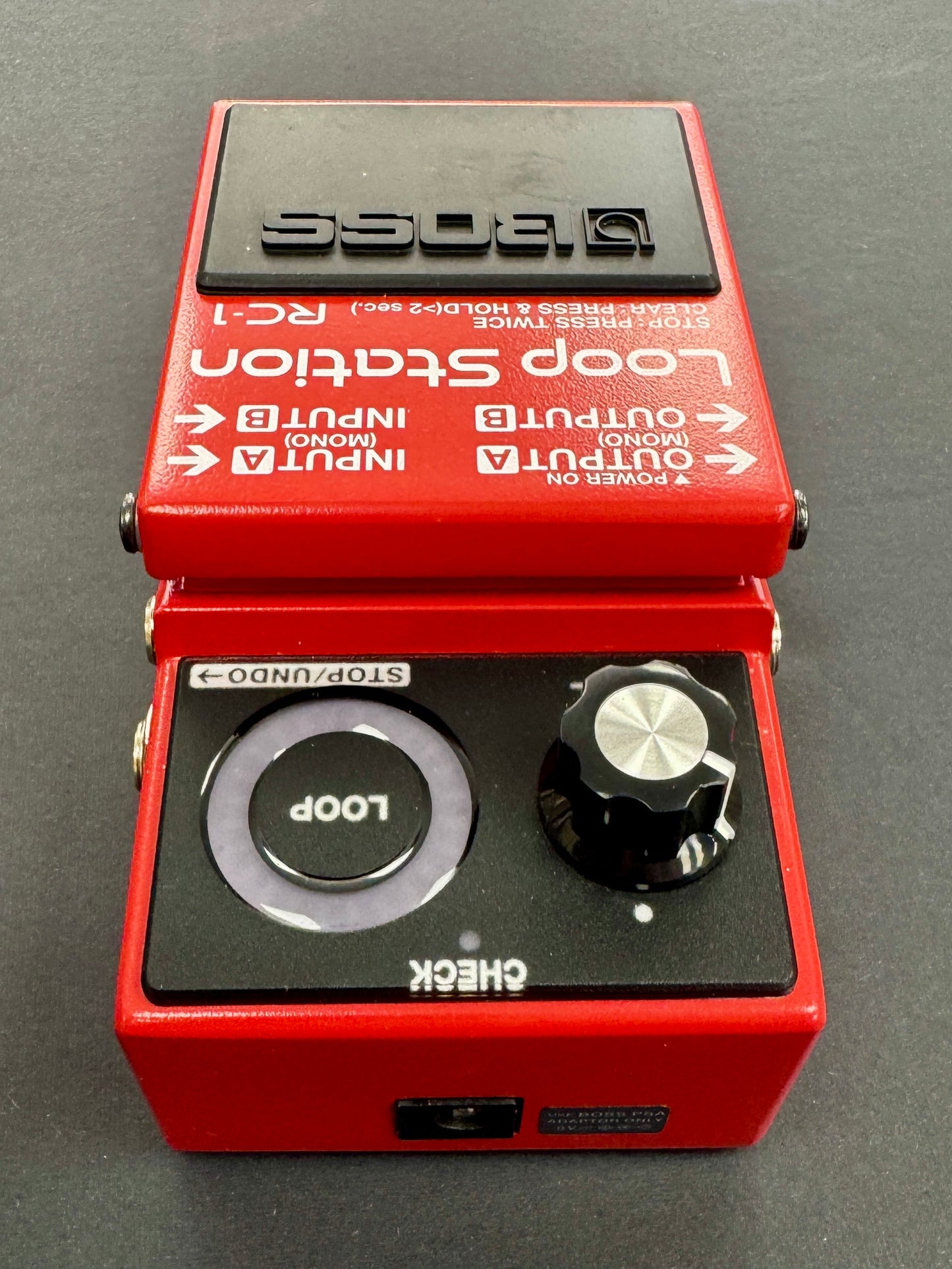 Red Boss Loop Station RC-1 guitar effects pedal on a gray background