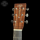 Close-up of a Martin guitar headstock with brand name on a black background