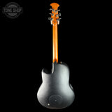 A dark metallic gray electric guitar shown from the back, featuring a glossy orange neck and headstock, set against a solid black background with a Tone Shop watermark in the top-left corner.