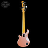 Electric bass guitar with a rose gold body and blonde neck on a black background, featuring 'Tone Shop' branding.