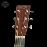 Close-up of a Martin guitar headstock with brand logo on a black background