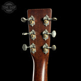 Close-up of a guitar headstock with tuning pegs on a black background, featuring the Tone Shop logo.