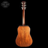 Back view of a wooden acoustic guitar on a black background with 'Tone Shop' logo.