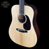 Acoustic guitar with a visible brand logo on a black background