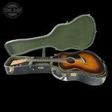 Open guitar case with an acoustic guitar inside, branded 'Tone Shop'.