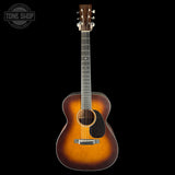 Acoustic guitar with a sunburst finish on a black background, featuring the Tone Shop logo.