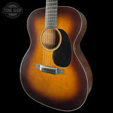 Acoustic guitar with a sunburst finish on a black background, featuring the Tone Shop logo.