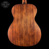 Close-up of a wooden acoustic guitar back with 'Tone Shop' logo.