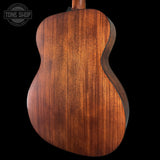 Close-up of a wooden acoustic guitar body with 'Tone Shop' logo.