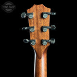 Taylor guitar headstock with tuning pegs on a black background