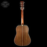 Back view of a wooden acoustic guitar with 'Tone Shop' logo in the corner.