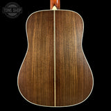 Back view of a wooden acoustic guitar with 'Tone Shop' logo.