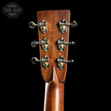 Close-up of a guitar headstock with tuning pegs on a black background, featuring the Tone Shop logo.