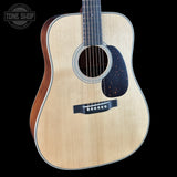 Acoustic guitar with a visible brand logo on a black background