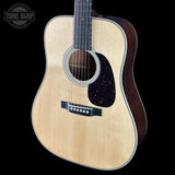 Acoustic guitar with a visible brand logo on a black background