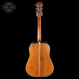 Back view of a wooden acoustic guitar on a black background with 'Tone Shop' logo.