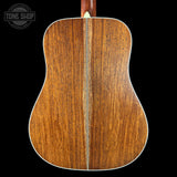 Back view of a wooden acoustic guitar with 'Tone Shop' logo.