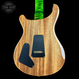 The back of an electric guitar with a natural wood finish, black pickguard, and a bright green wrapped neck, shown against a black background with a Tone Shop watermark.
