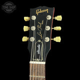 Close-up of a Gibson Les Paul Custom acoustic guitar headstock, featuring cream tuning pegs, gold Gibson and Les Paul lettering on a black background, with a Tone Shop watermark in the upper left corner.