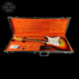 Electric guitar in an open case with a 'Tone Shop' logo in the corner.