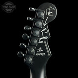 Close-up of a guitar headstock with tuning pegs on a black background, featuring the 'Tone Shop' logo.