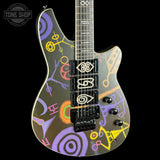 Guitar with colorful abstract design on a black background, featuring the Tone Shop logo.