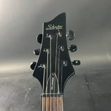 Guitar headstock with 'Schecter' branding on a reflective surface