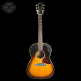 A vintage acoustic guitar with a sunburst finish, shown against a solid black background. The brand 'Tone Shop' is watermarked in the top-left corner.