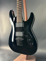 Black electric guitar on a reflective surface